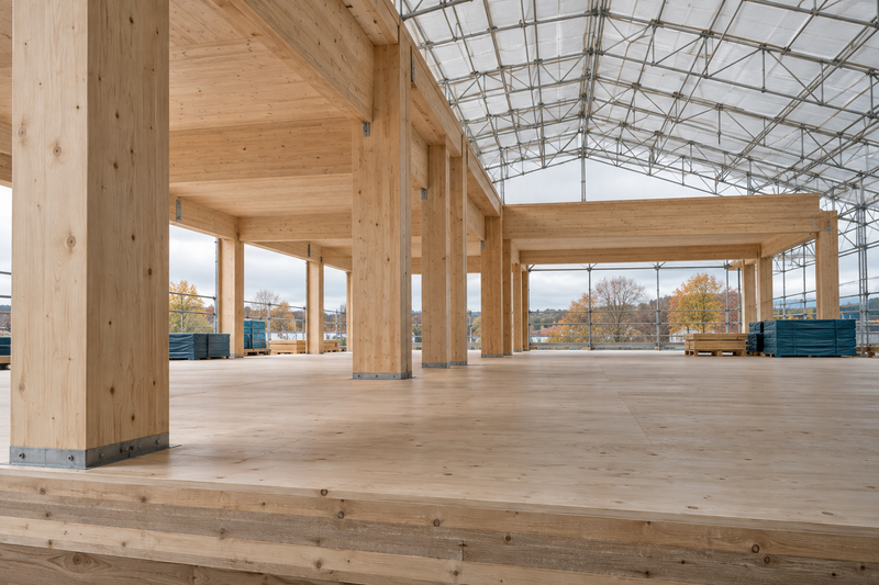 AI illustration of an unfinished mass timber interior beneath temporary overhead weather protection.