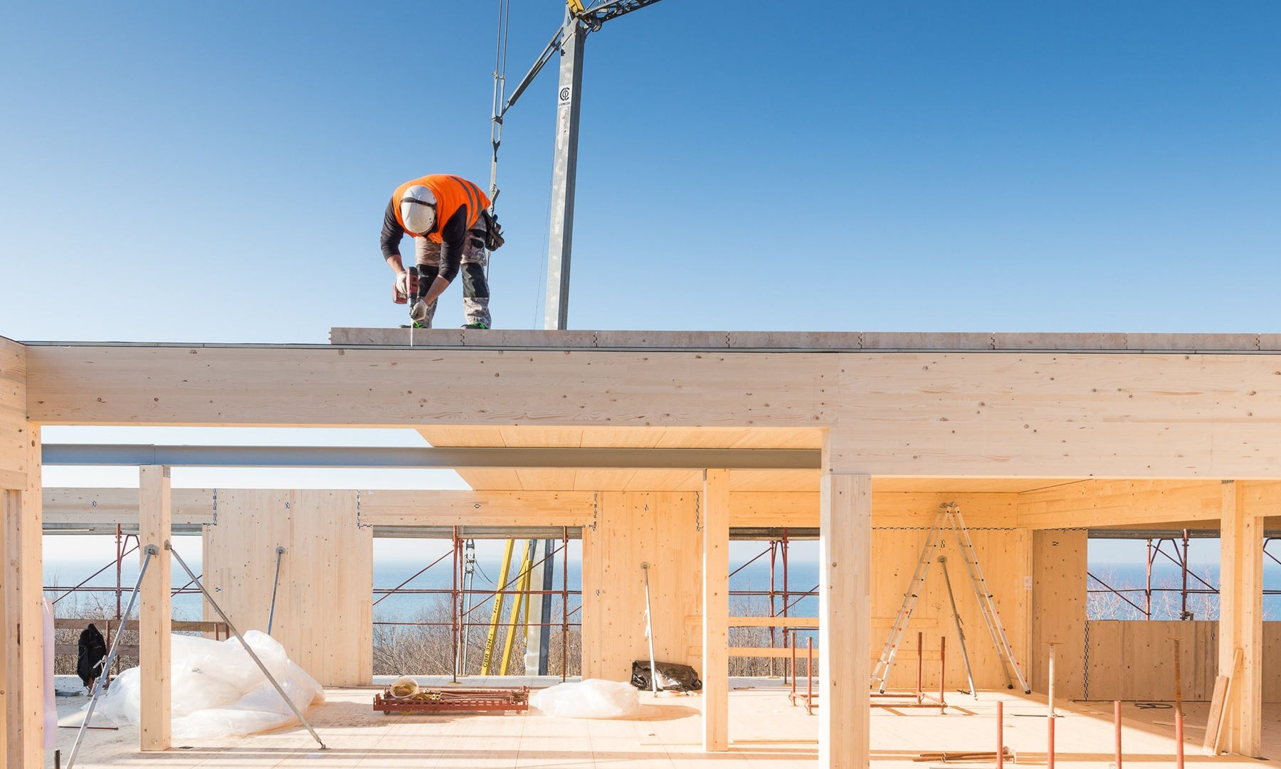 Installer fixing a CLT mass timber panel on a construction site